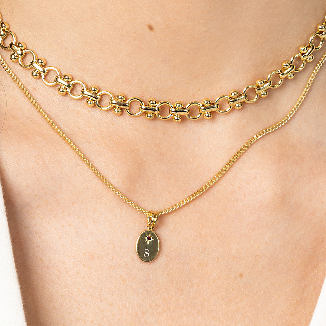 Gold chain necklaces on a person's neck with a close-up view.