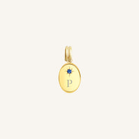 Gold pendant with 'A' initial on a light beige background