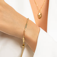 A gold Etch chain bracelet with three panels for engraving, featuring an adjustable fastening mechanism.