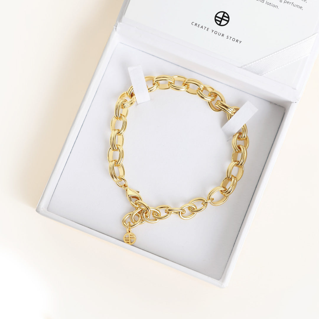Gold chain bracelet in a white box with 'Create Your Story' branding.