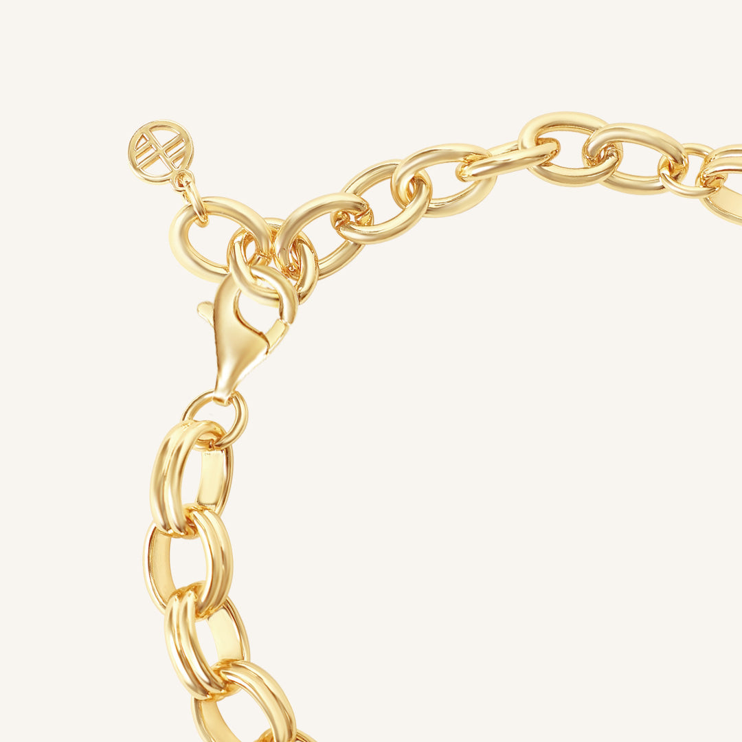 Gold chain bracelet on a light beige background