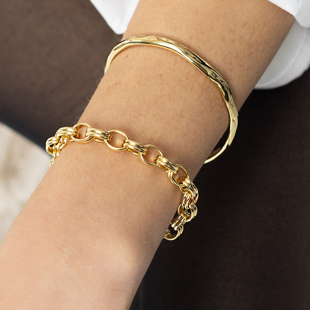 Gold bracelet on a wrist with a blurred background