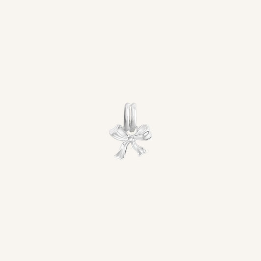 A small silver bow charm with a loop on top for attachment, displayed on a white background.