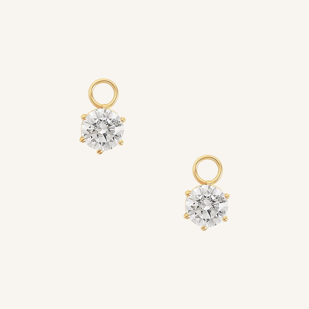 A set of two hoop charms with gold metal tone, designed to be attached to earrings.