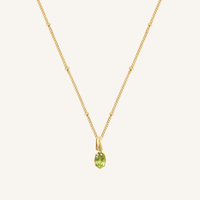 A green, oval-shaped charm pendant necklace with a gold metal chain.