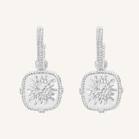 Pair of silver earrings with sun design on a white background