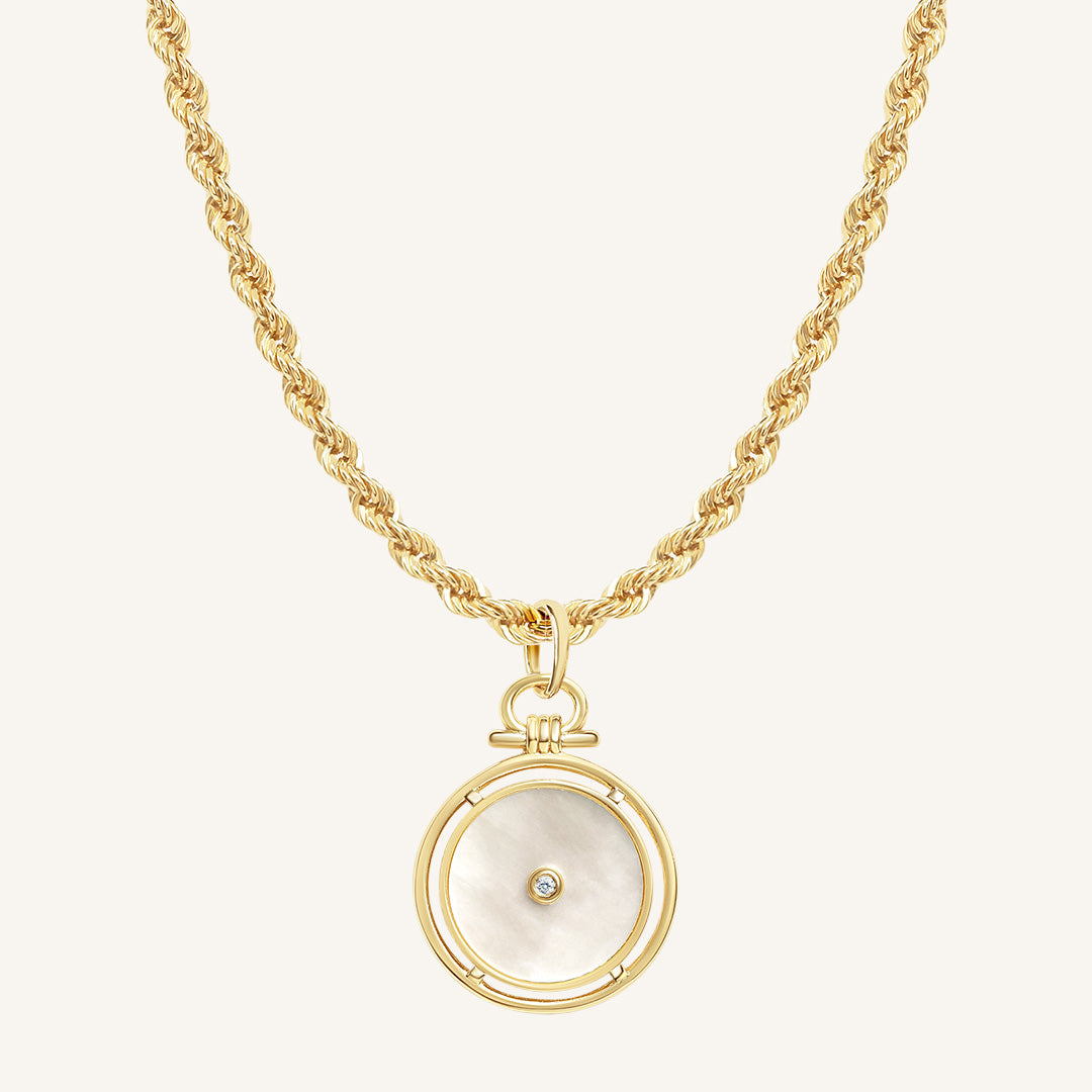 Gold necklace with a circular pendant on a white background