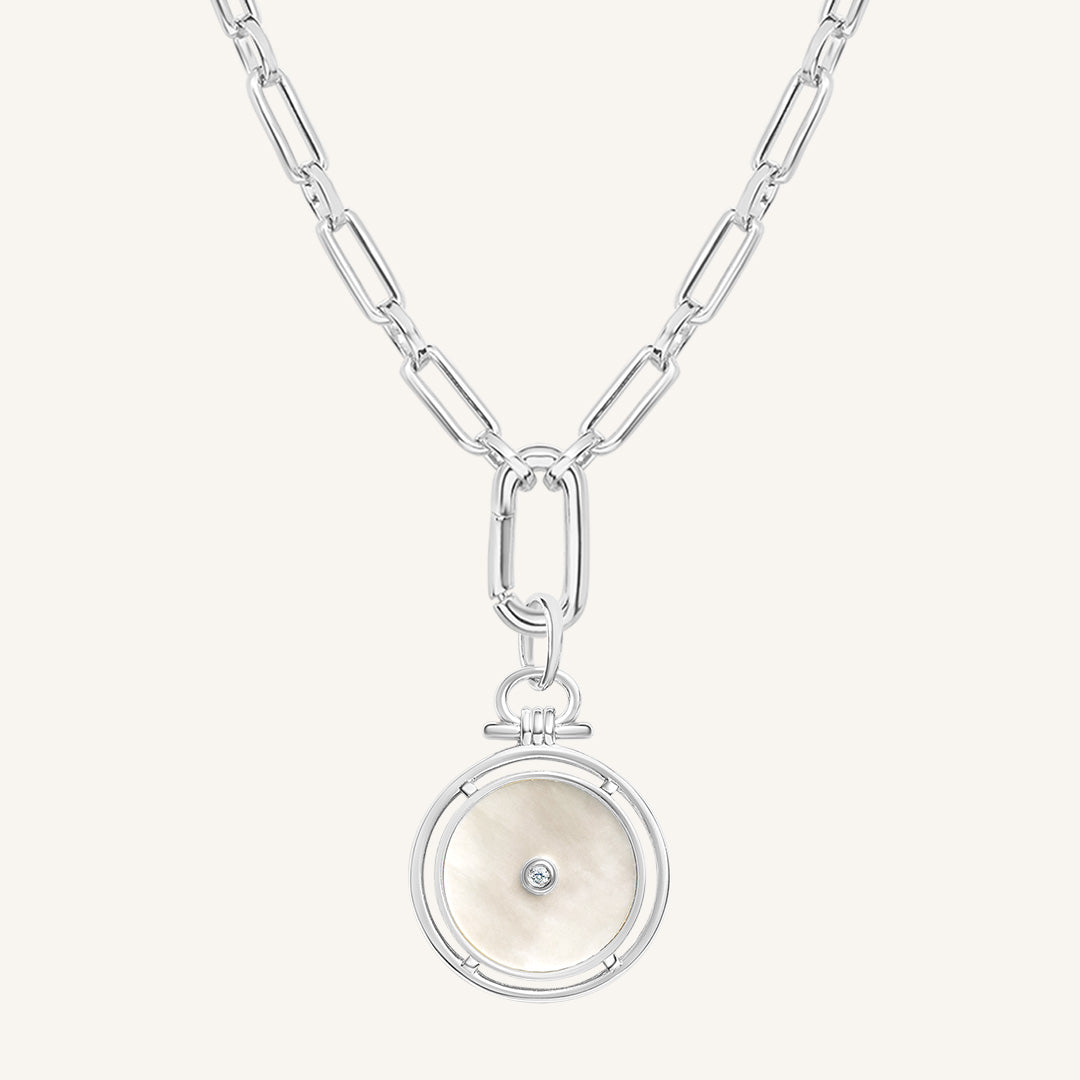 Silver necklace with a round pendant on a white background