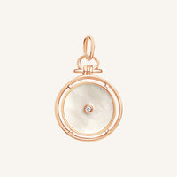 Rose gold pendant with a white circular face and central gemstone on a light beige background