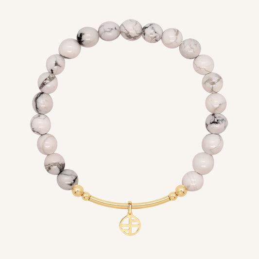 Bracelet with white beads and gold clasp on a white background