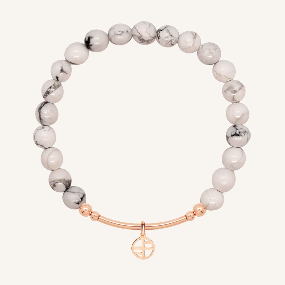 White beaded bracelet with a rose gold clasp on a white background