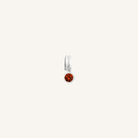 Round silver charm with bezel-set garnet cubic zirconia representing the January birthstone.

