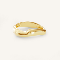 A gold-coloured ring with an irregular, smooth shape on a white background