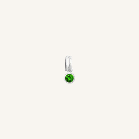 A silver, round bezel set emerald cubic zirconia reflects May birthstone colour