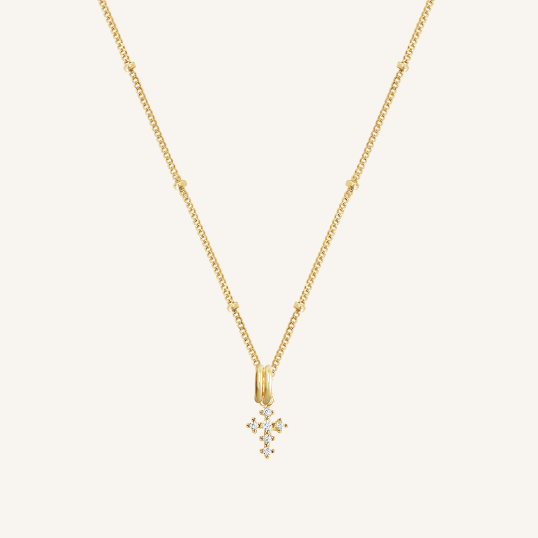 A gold-tone Nurture Cross Charm Pendant Necklace with a vintage cross shape on a chain.