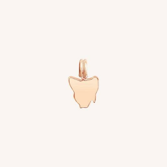 A rose-colored charm in the shape Tasmania