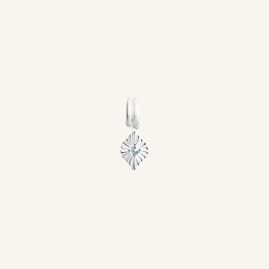 A silver birthstone charm with a blue cubic zirconia representing the month of March.