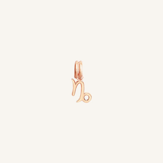 A rose gold Petite Zodiac Charm representing the Capricorn sign.
