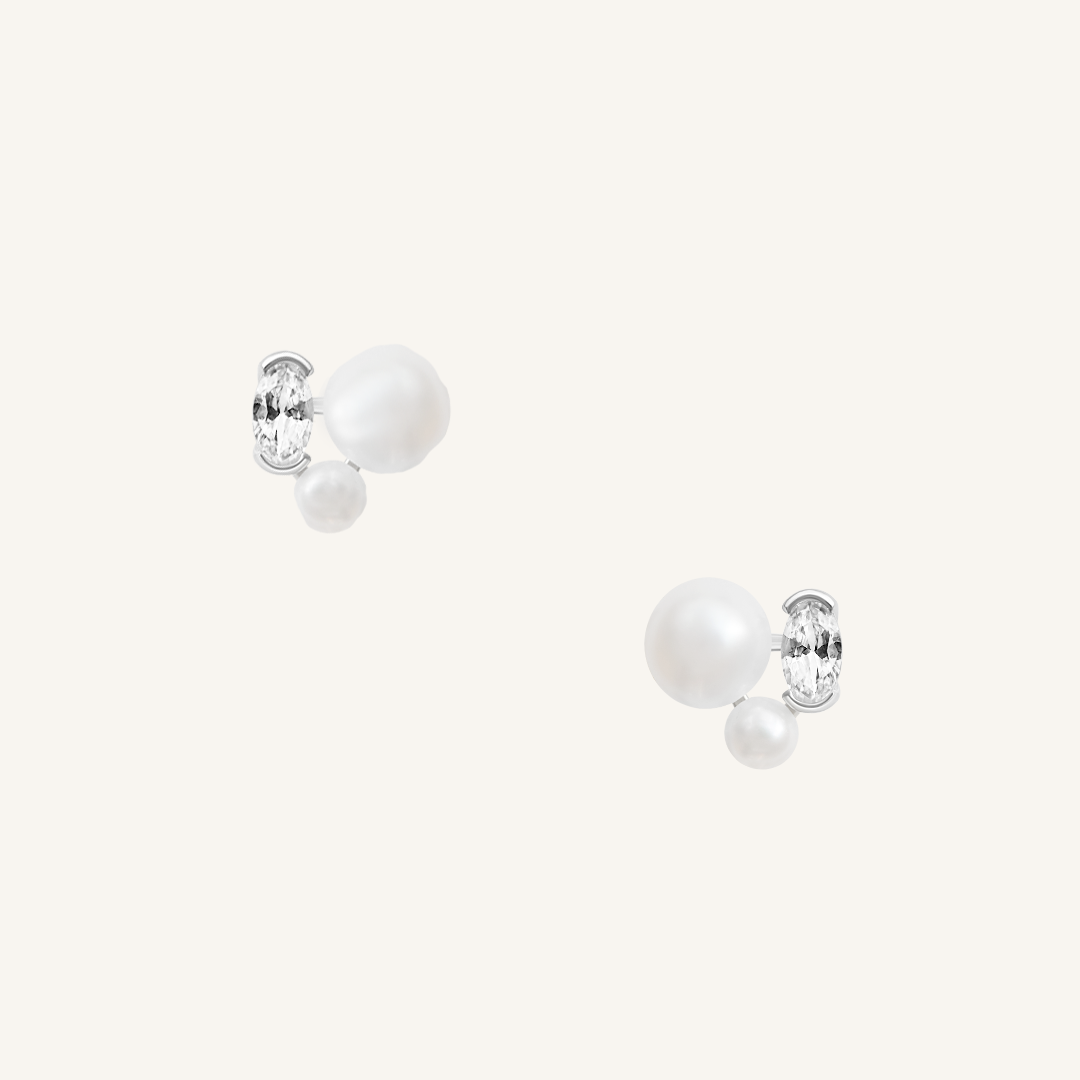 A pair of pearl stud earrings with gold accents on a white background.