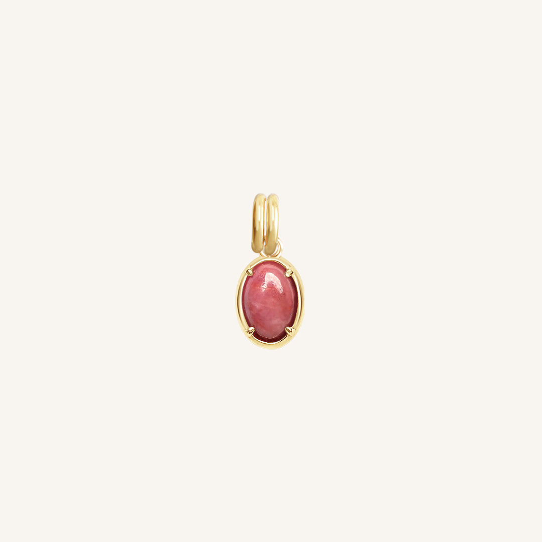 Gold pendant with a pink gemstone on a white background