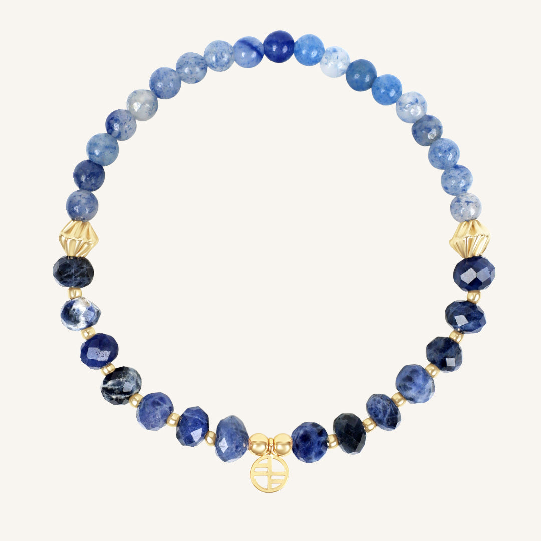 Blue beaded bracelet with gold accents on a white background