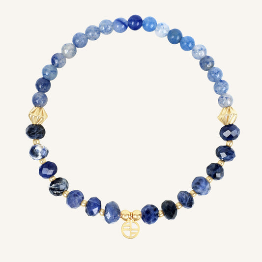Blue beaded bracelet with gold accents on a white background