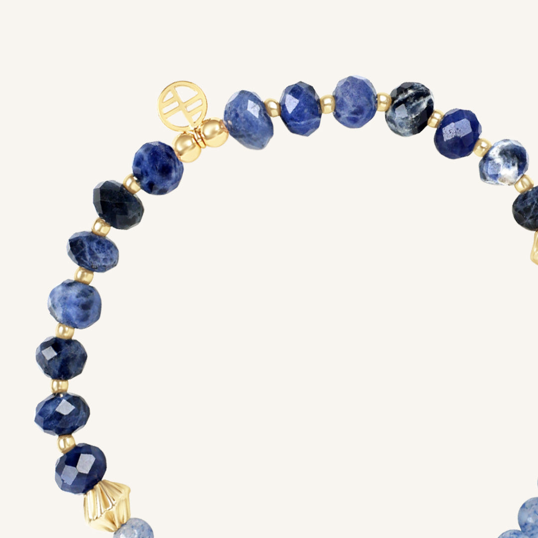 Bracelet with blue beads and gold accents on a white background
