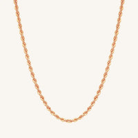 A rose rope chain necklace on a plain background.