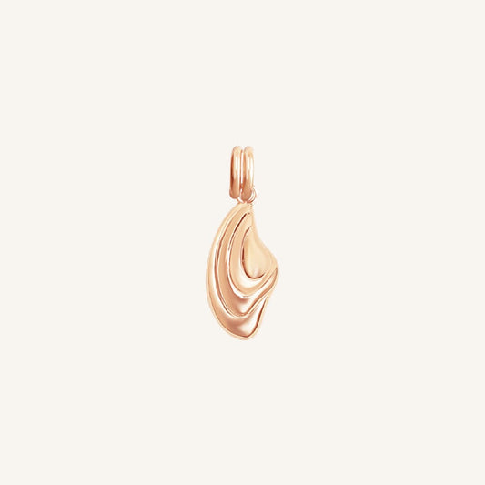 Rose gold pendant on a light beige background