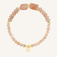 Bracelet with pink beads and gold accents on a white background