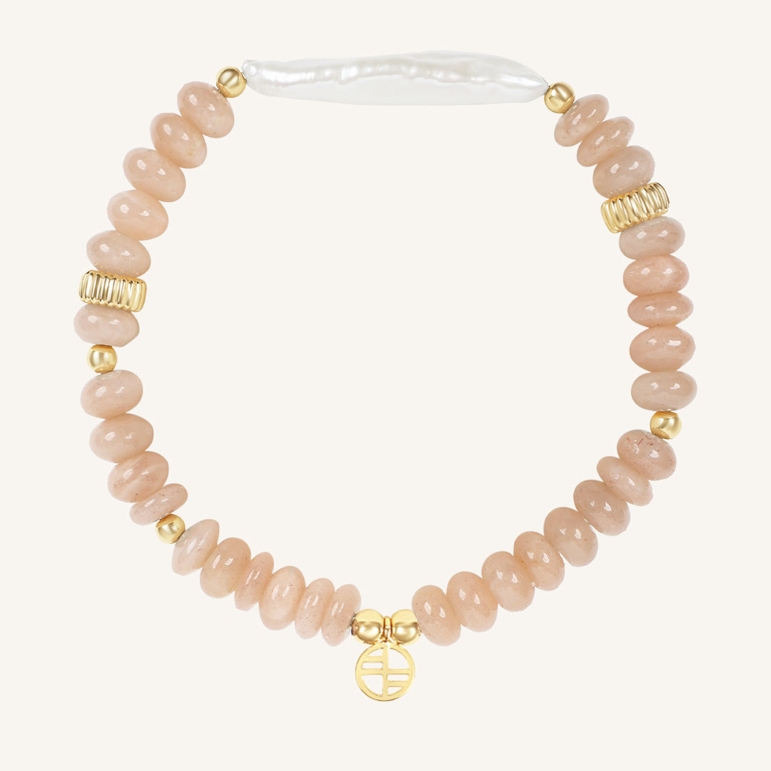 Bracelet with pink beads and gold accents on a white background
