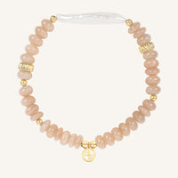 Bracelet with pink beads and gold accents on a white background