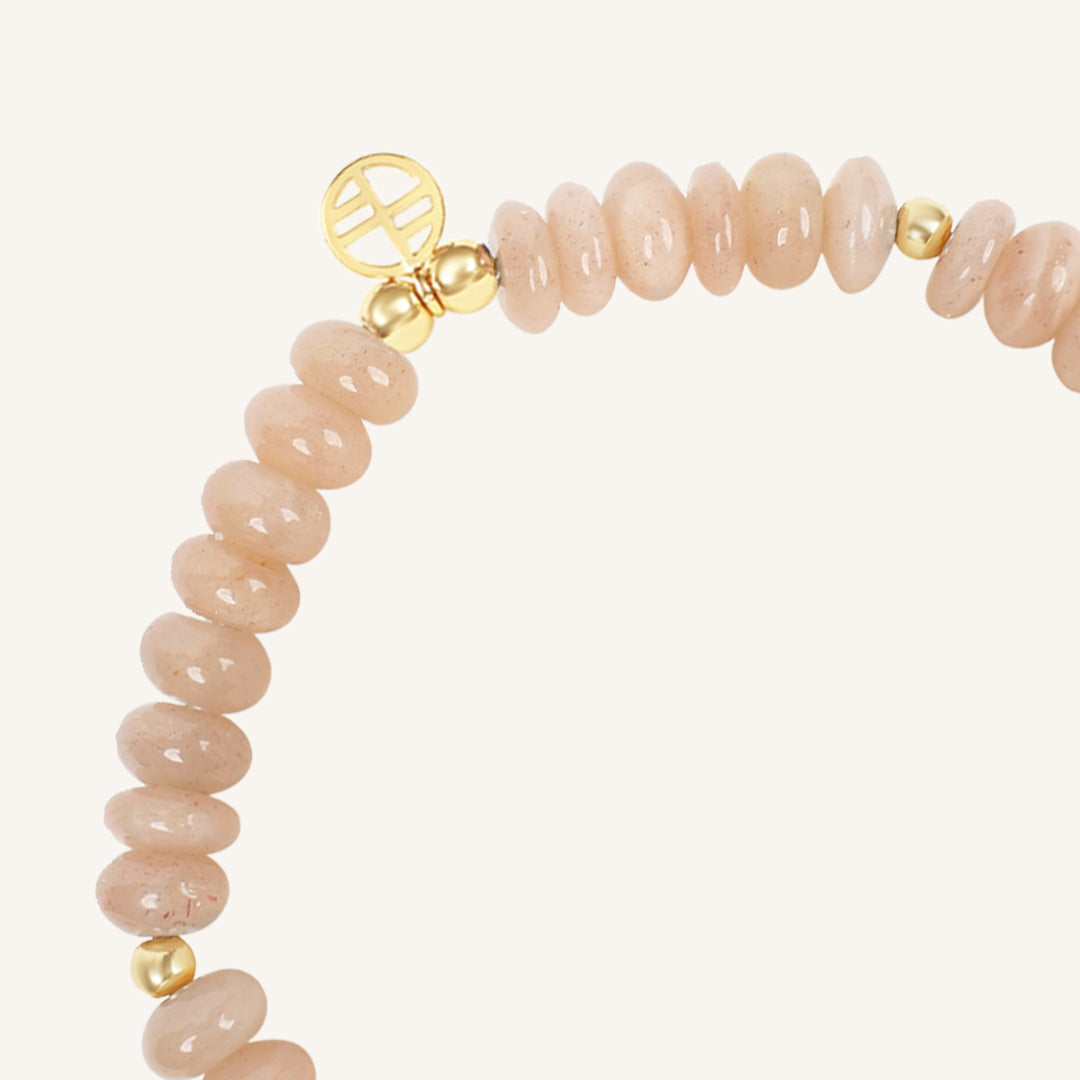Bracelet with pink beads and gold accents on a white background