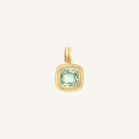 Gold pendant with a green gemstone on a white background