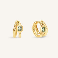 Gold hoop earrings with green gemstones on a white background