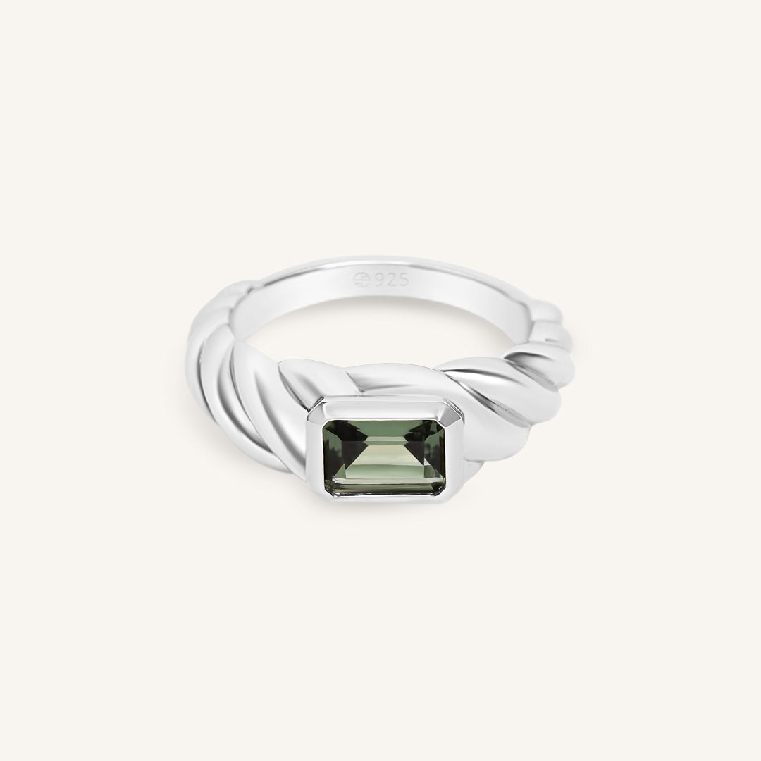 Silver ring with a green gemstone on a white background