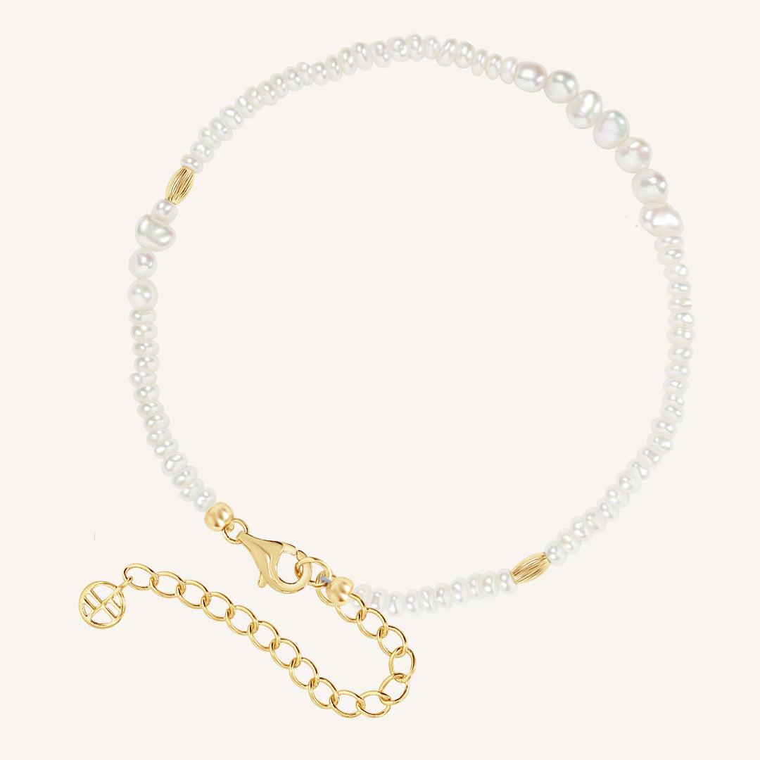 Pearl anklet with gold clasp on a white background