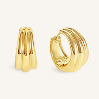 Gold hoop earrings on a light beige background