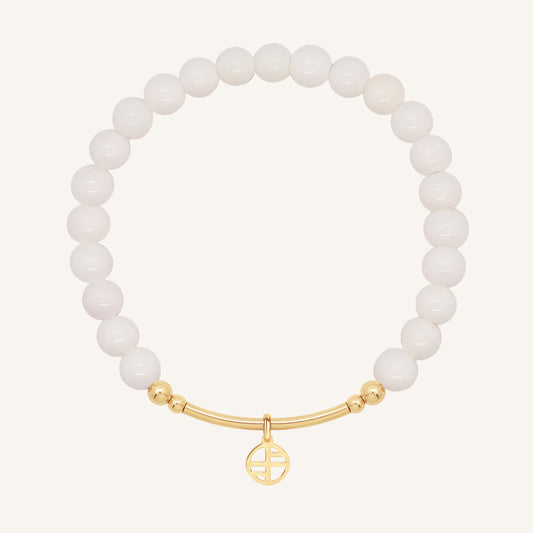 White beaded bracelet with a gold clasp on a white background
