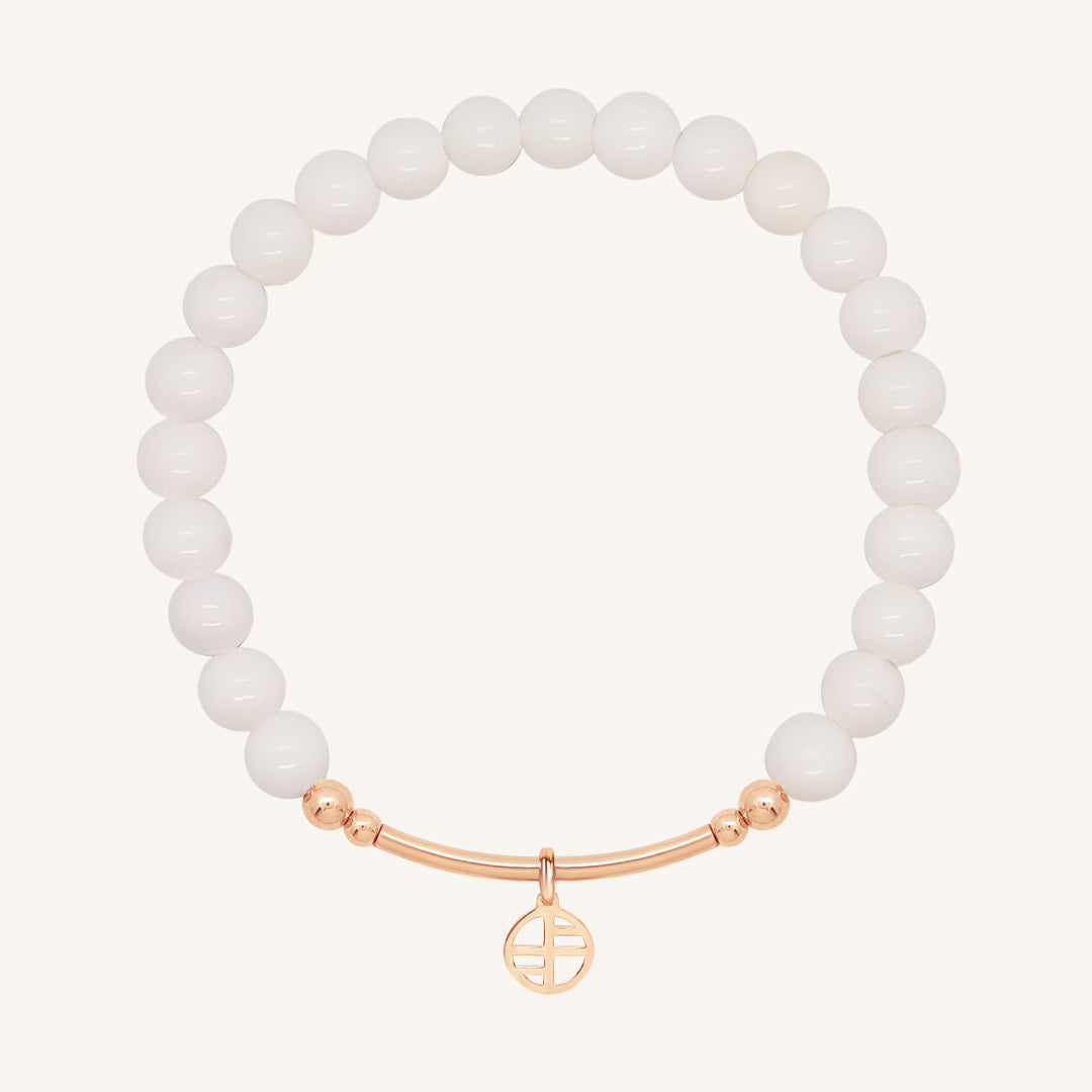 White beaded bracelet with a rose gold clasp on a white background