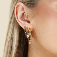 A pair of gold-colored hoop earrings on a white background