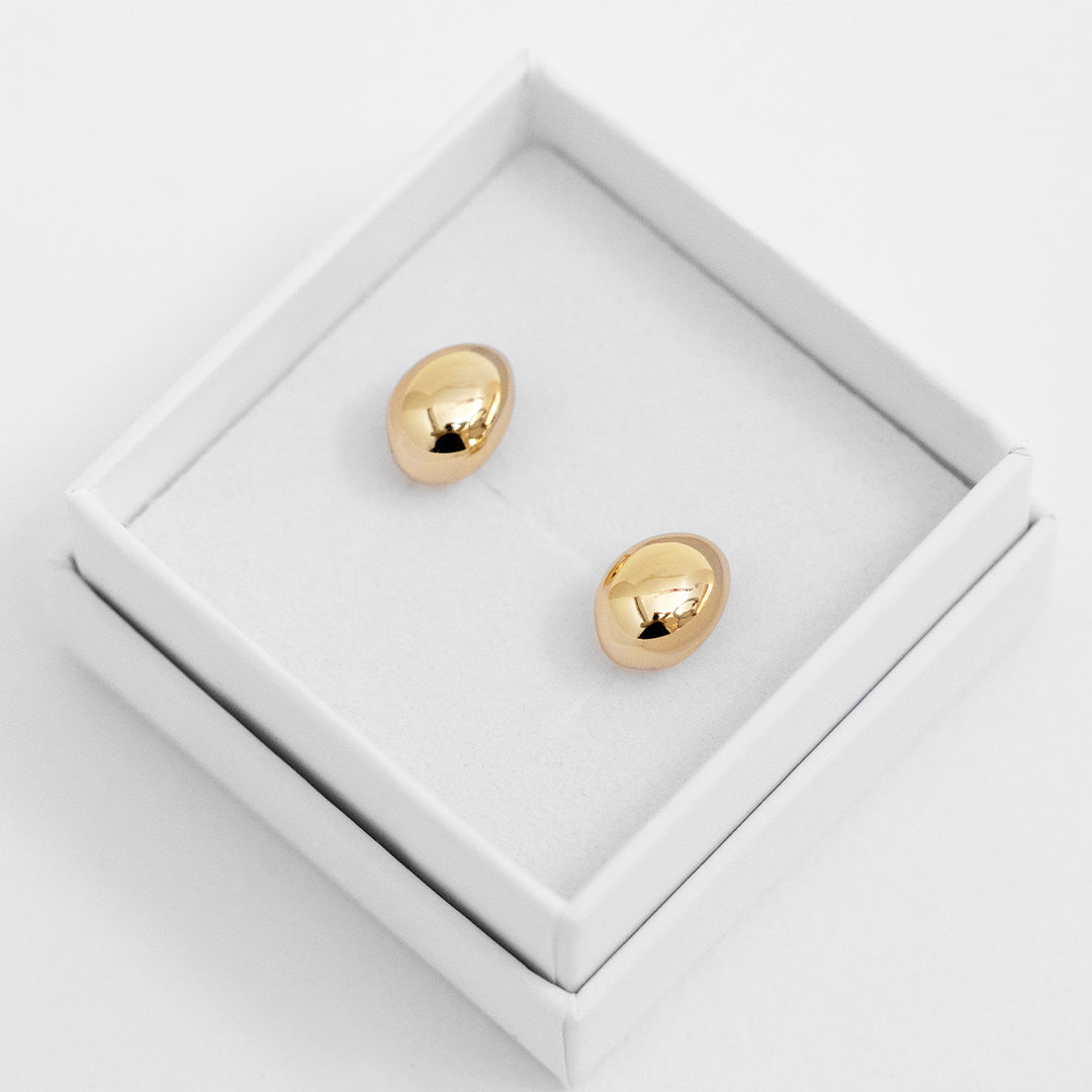A pair of chunky bulb-shaped earrings in gold tone.