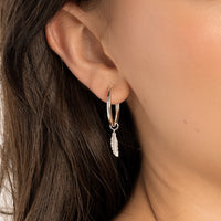 A set of two gold hoop charms with a feather design, on white background