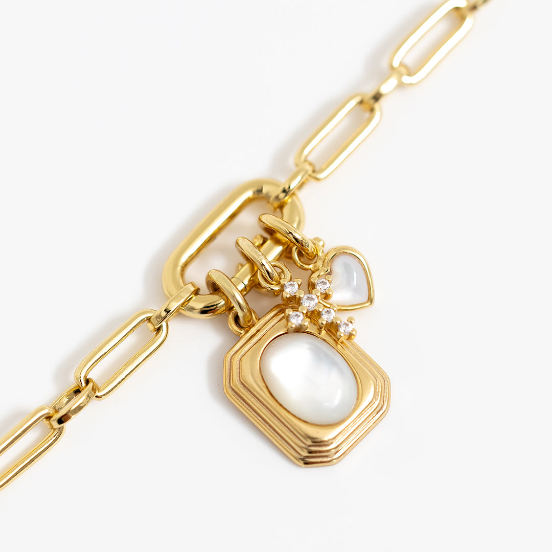 A petite gold cross charm with cubic zirconia on link chain, with charms 