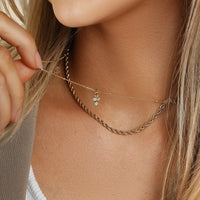 Petite gold charm with a rectangular and a round cubic zirconia, designed to be attached to a bracelet or necklace