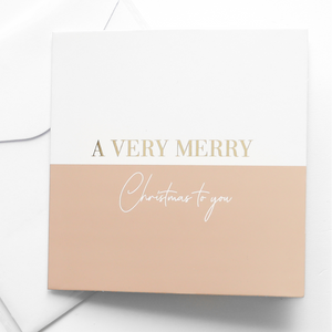 A greeting card with the words 'A VERRY MERRY CHRISTMAS TO YOU' printed in gold and white letters, accompanied by a white envelope.